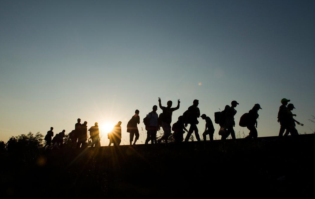 Migrants walking by sun