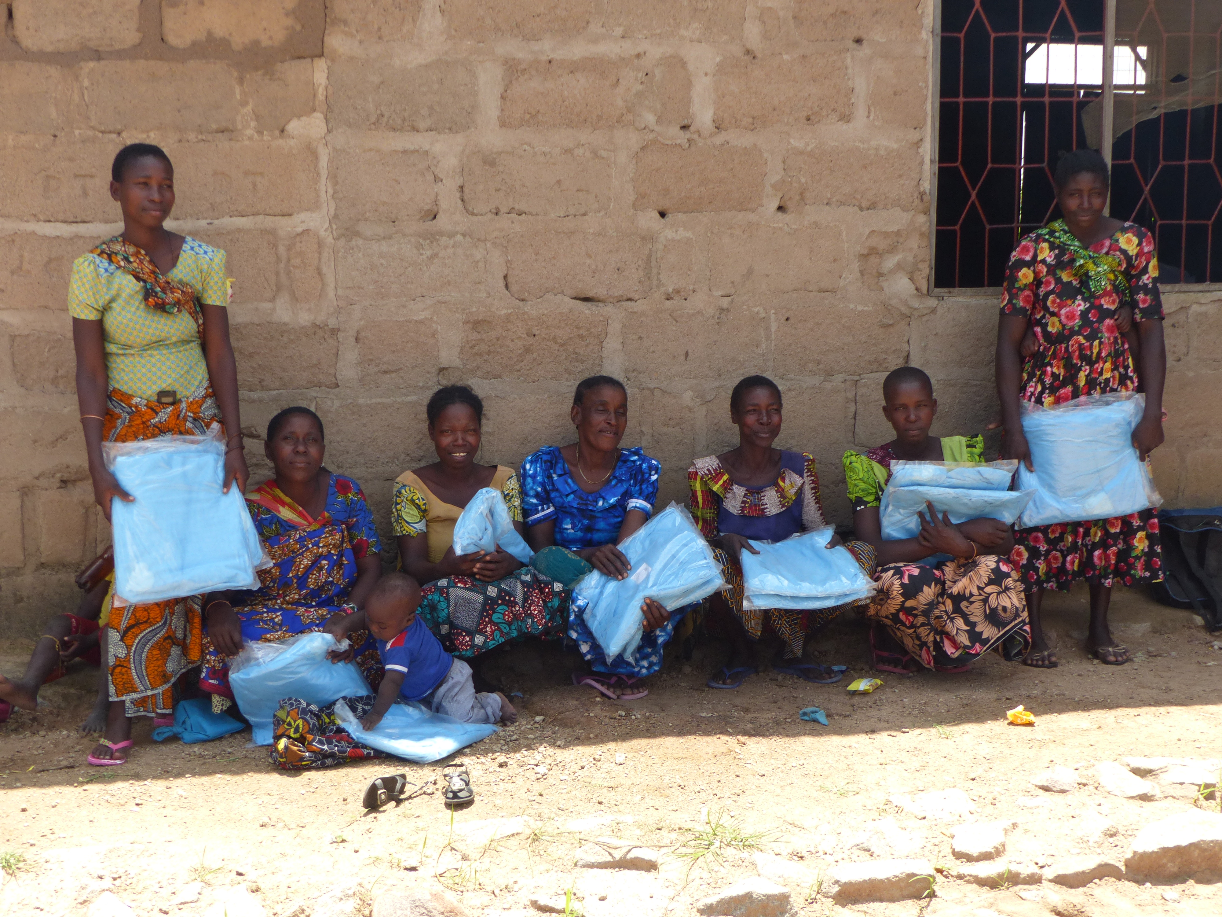 Women with mosquito nets, colorful Kanga. Busolwa, Misungwi, Tanzania. Credit: Natacha Protopopoff for LSHTM