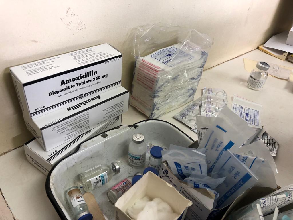 Boxes of antibiotics, vials and medical equipment on top of a table.