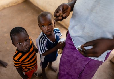 Two young boys wait to be given their does of anti-malarials, Basse, The Gambia. Credit: Louis Leeson/LSHTM