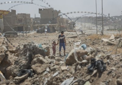 Young boy and small child behind barbed wire in Mosul