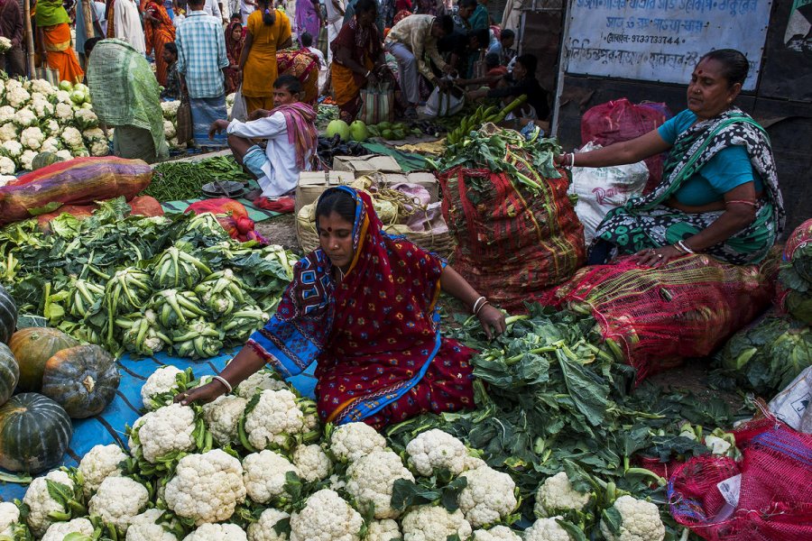 Women arranging vegetables to sell at a market in India