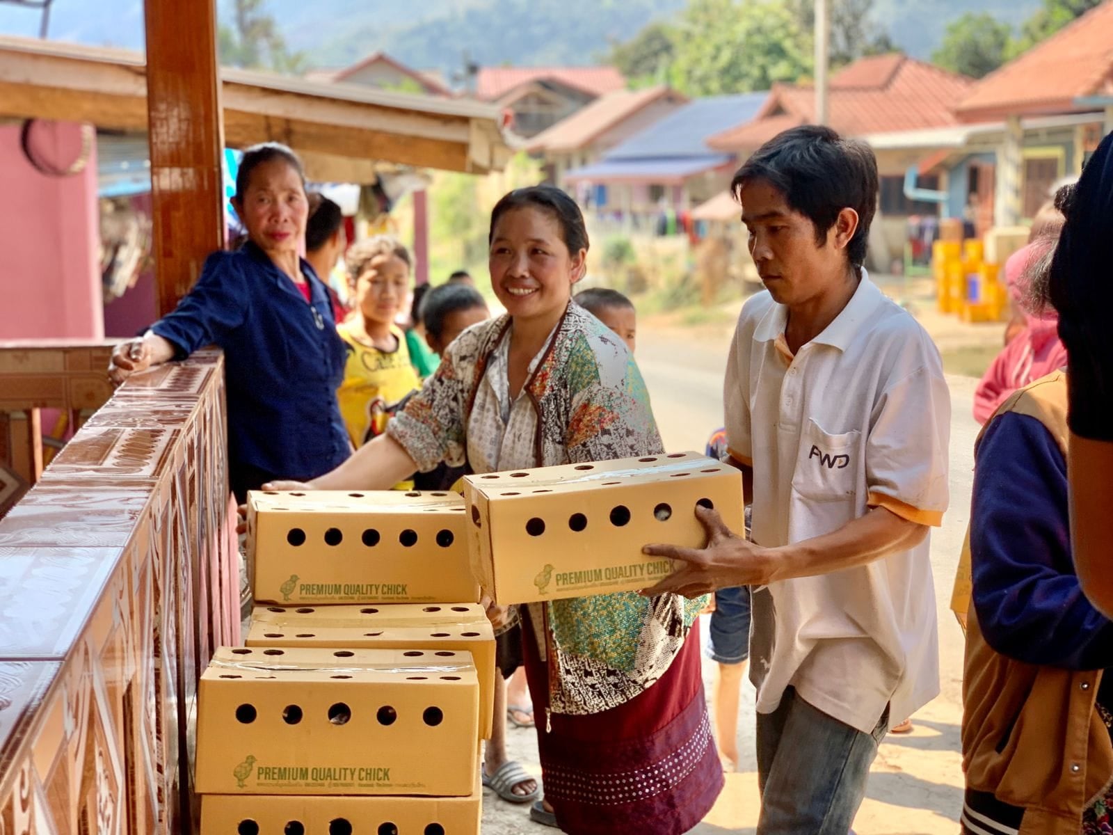 A man and woman in Laos stack boxes of chicken eggs