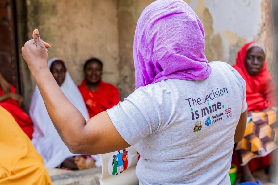 A woman, one of the community inclusive champions, is holding her hand up and explaining during the IFPLAN workshop with married women in Nigeria.