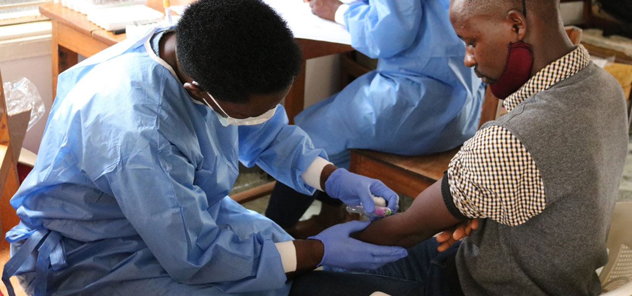 A nurse drawing blood samples from a GPC study participant in Kyamulibwa