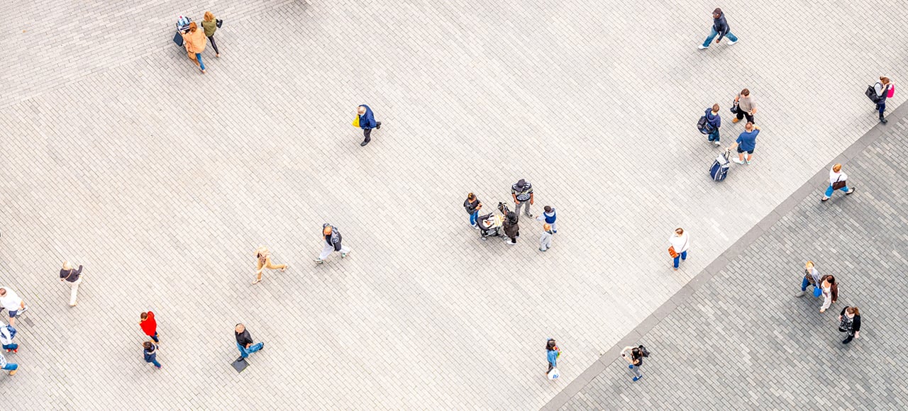 People walking in a large urban outdoor pedestrianised area, photographed from directly above