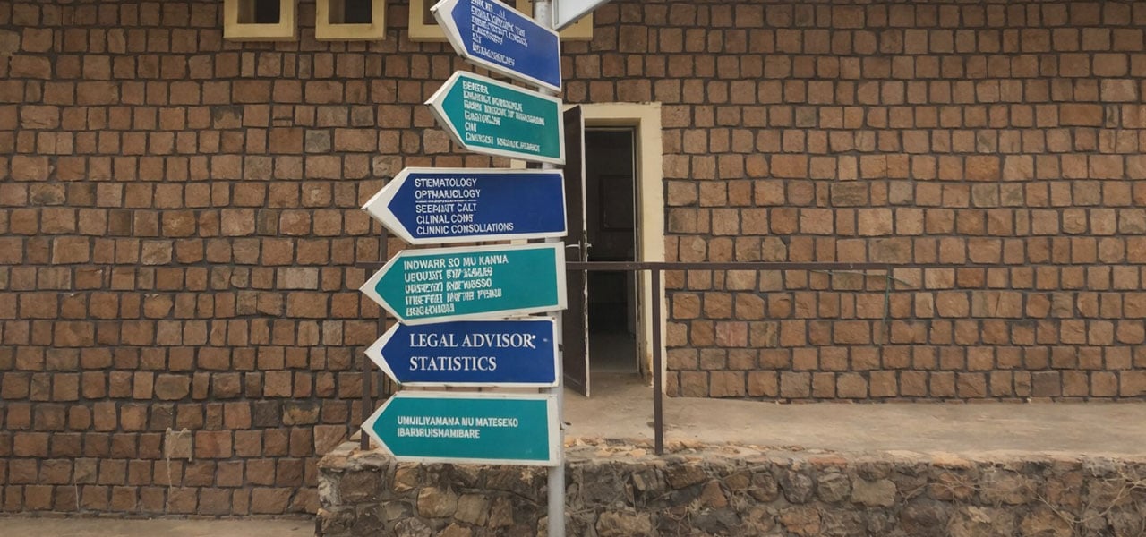 Signage to different hospital departments including the legal advisor and statistical department with a brick wall background. Credit: Francis Ruiz