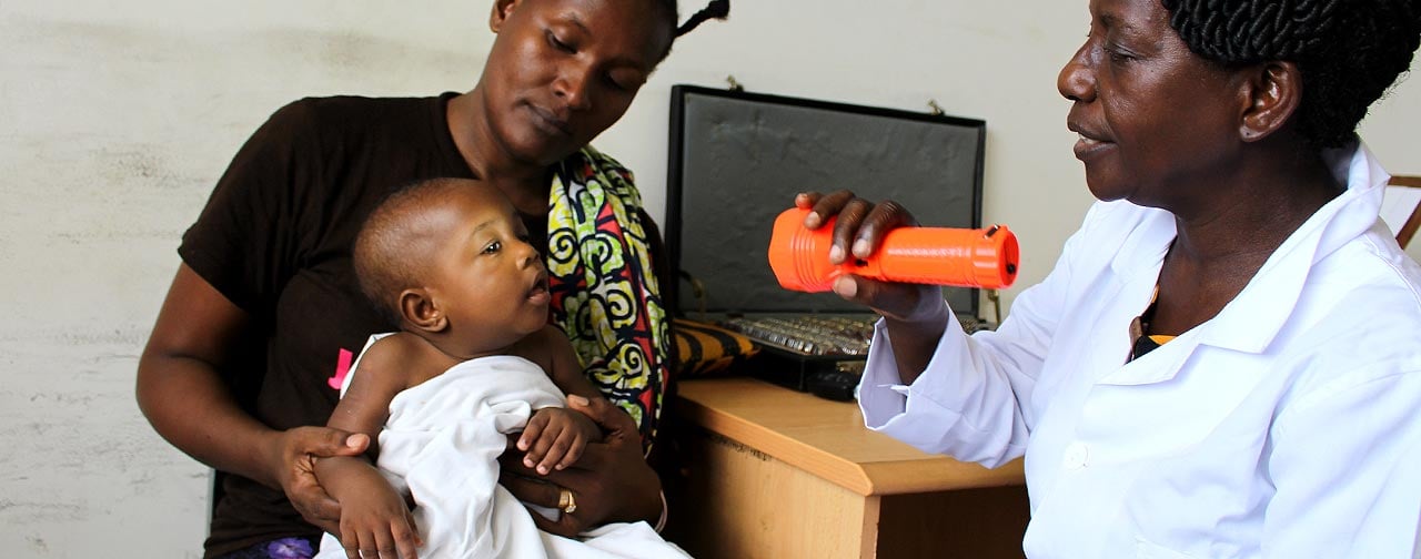 Healthcare worker examining child's sight