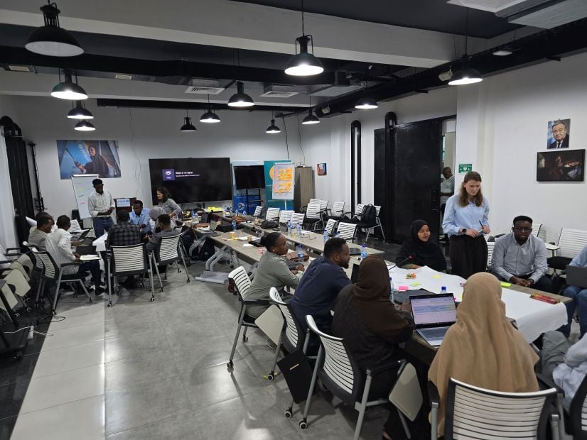 People sitting in conference room working in groups in Somalia