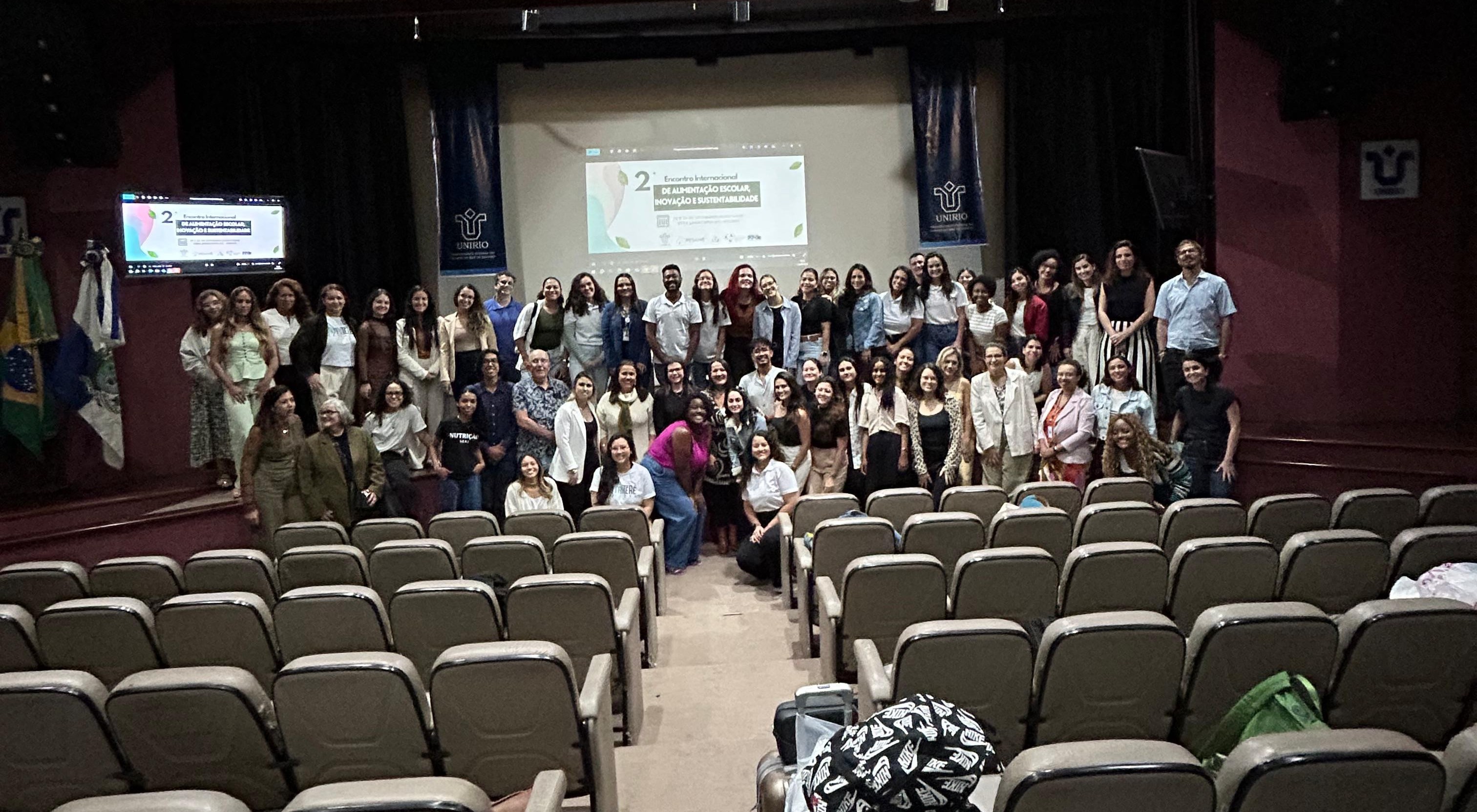 A group of people pose for a picture in an auditorium