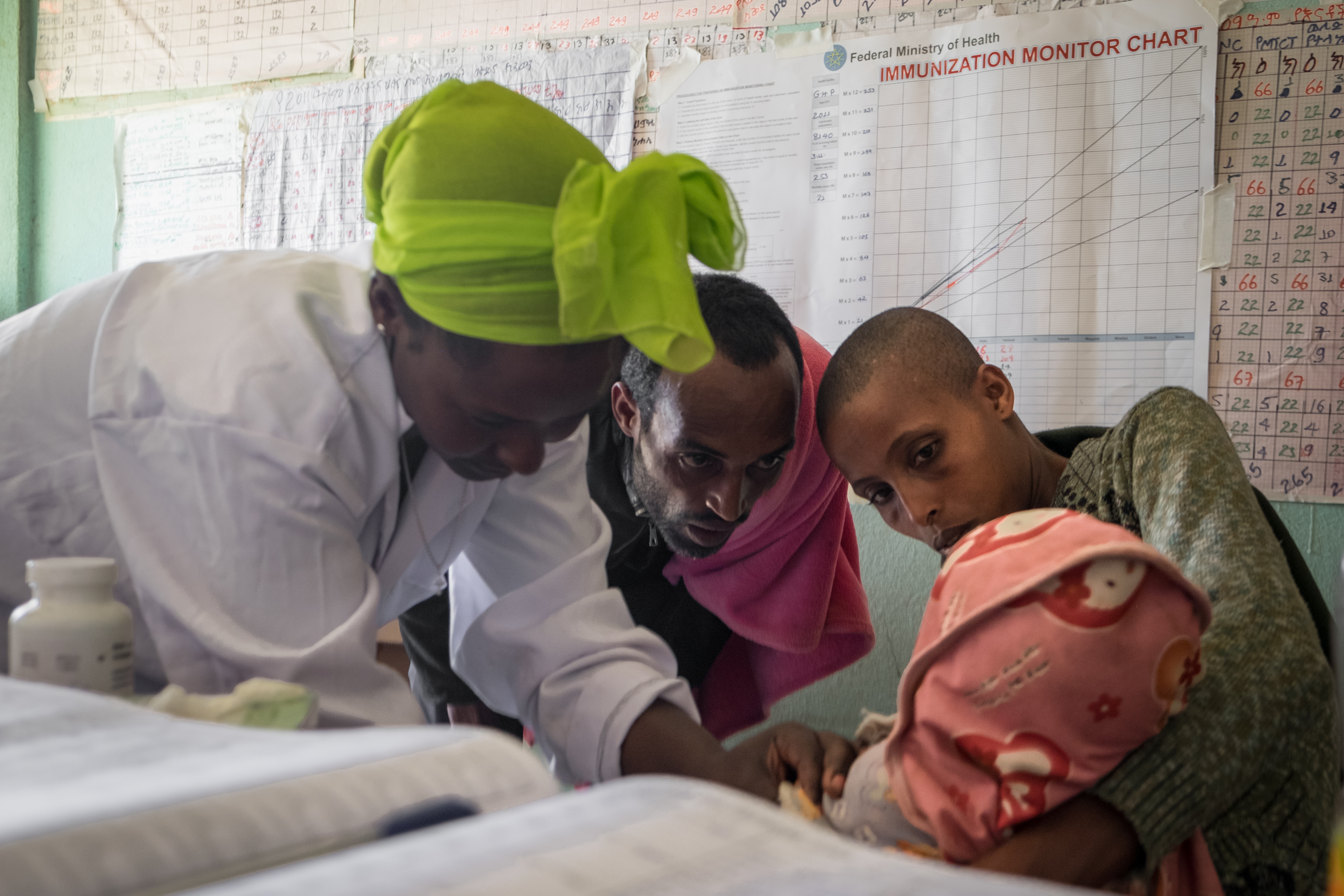 A health care worker examines a baby in Addis Kidam Health post