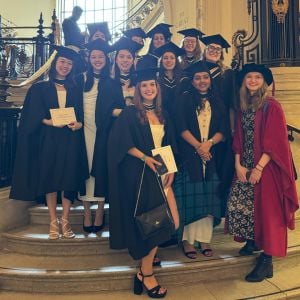 Group of students wearing graduation cap and gown at the LSHTM graduation venue.