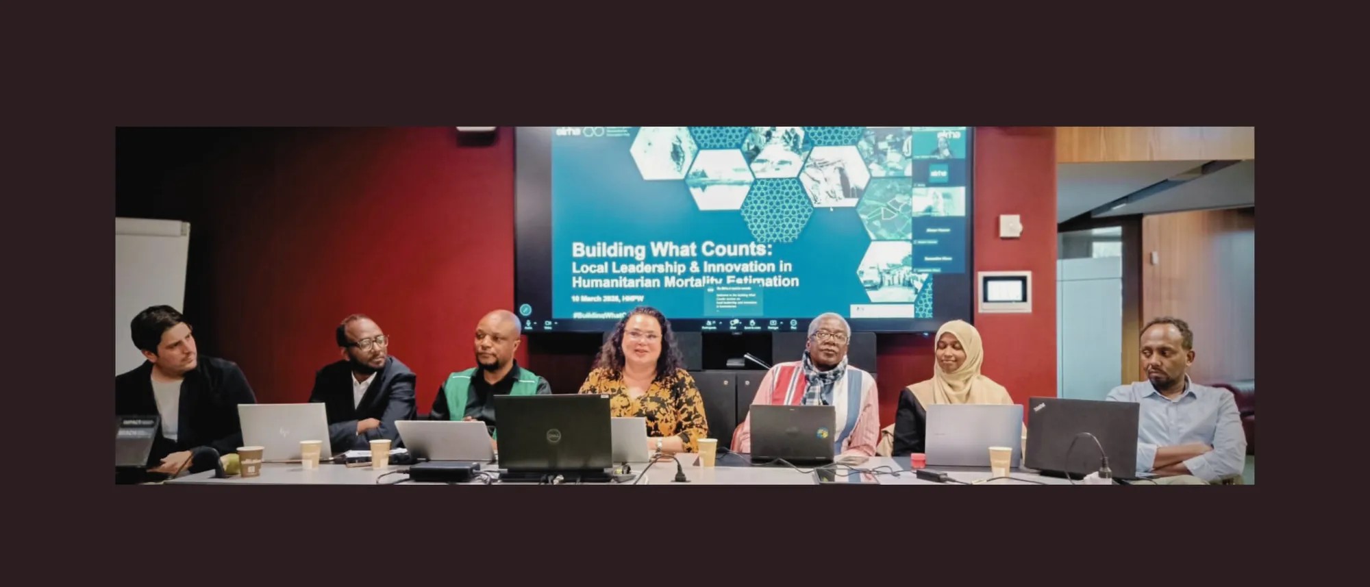 A diverse panel of speakers sit behind a long table. Photo Credit: Dr Jennifer Palmer