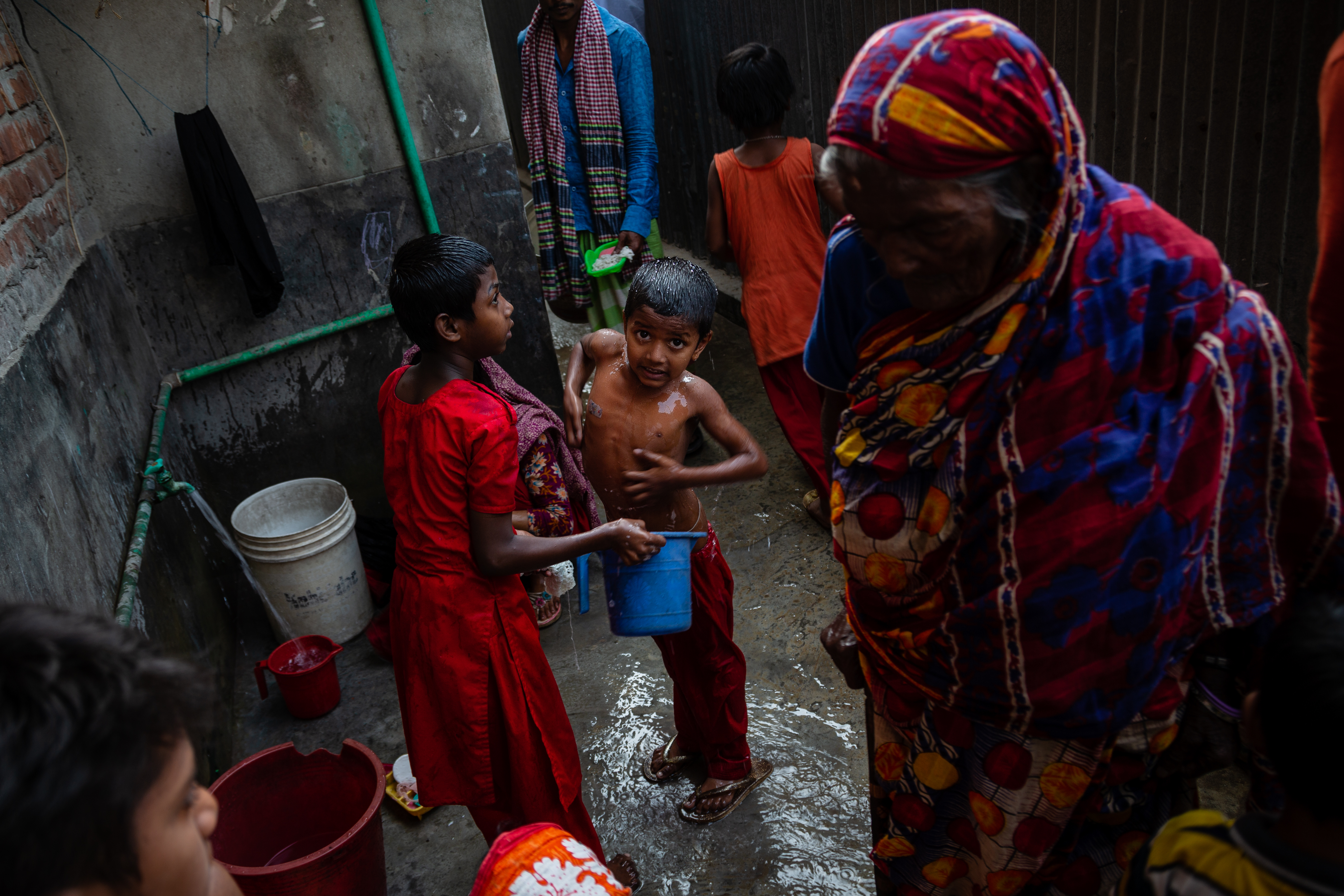 Caption: child washes in a Kamrangichar slum, Dhaka. Credit: Louis Leeson