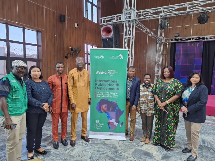 Workshop attendees standing next to branded banner