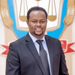 Dr Najib Issie Dirie, a Somali man, wears a black suit and tie and blue shirt