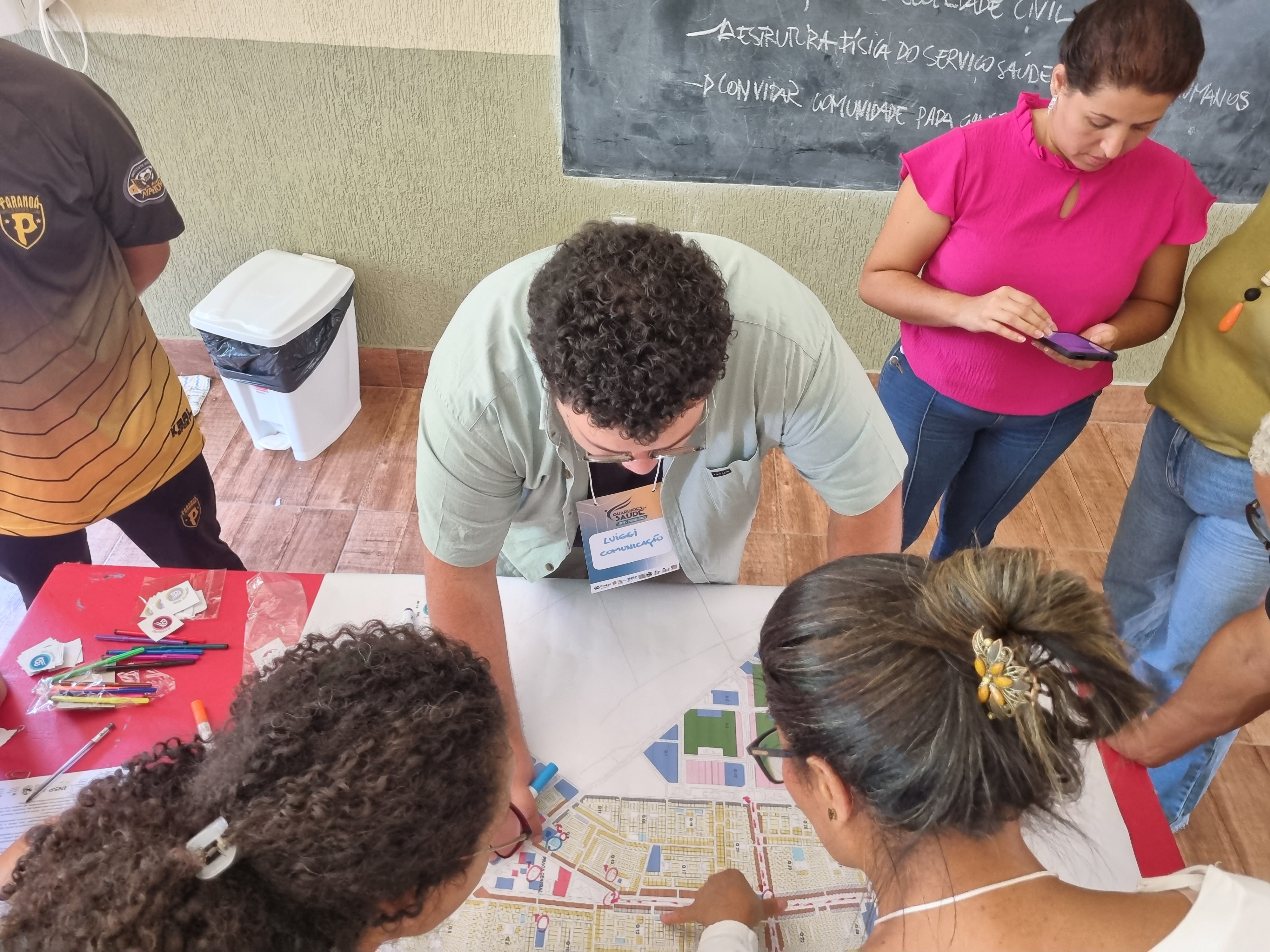 overhead shot of Brazil workshop participants looking at map on table