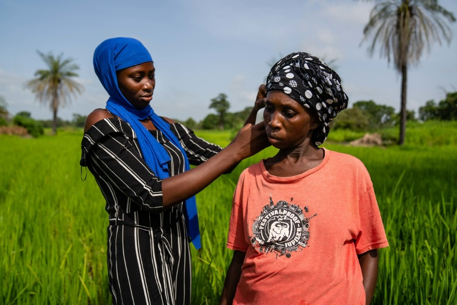 Researcher taking temperature of woman farmer in The Gambia