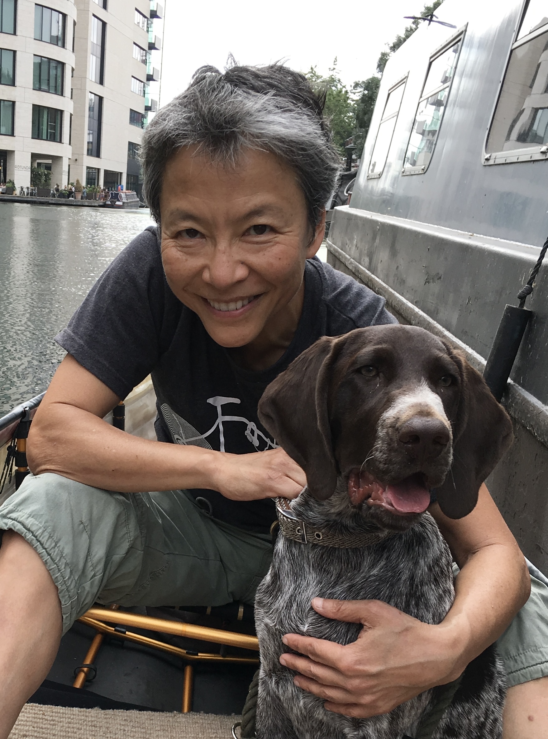 Shunmay Yeung and dog in a boat