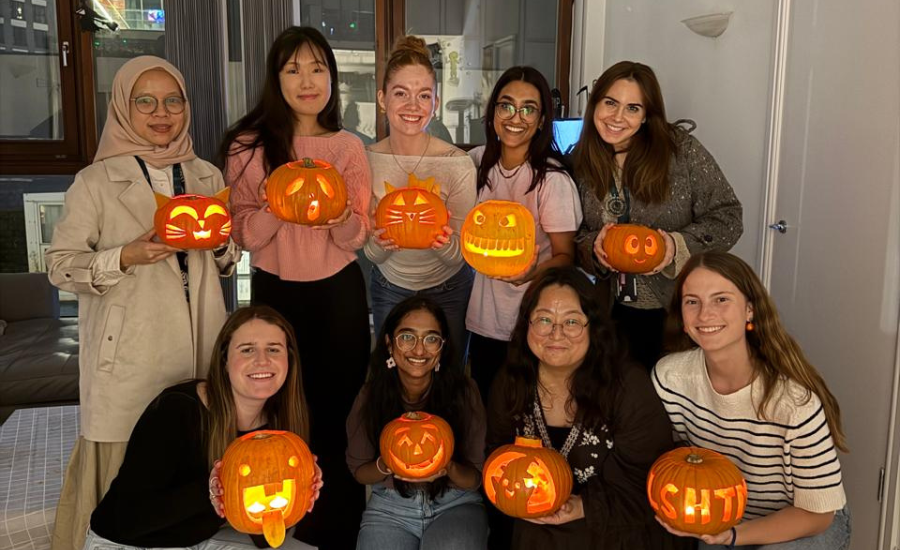 LSHTM Students holding carved pumpkins.