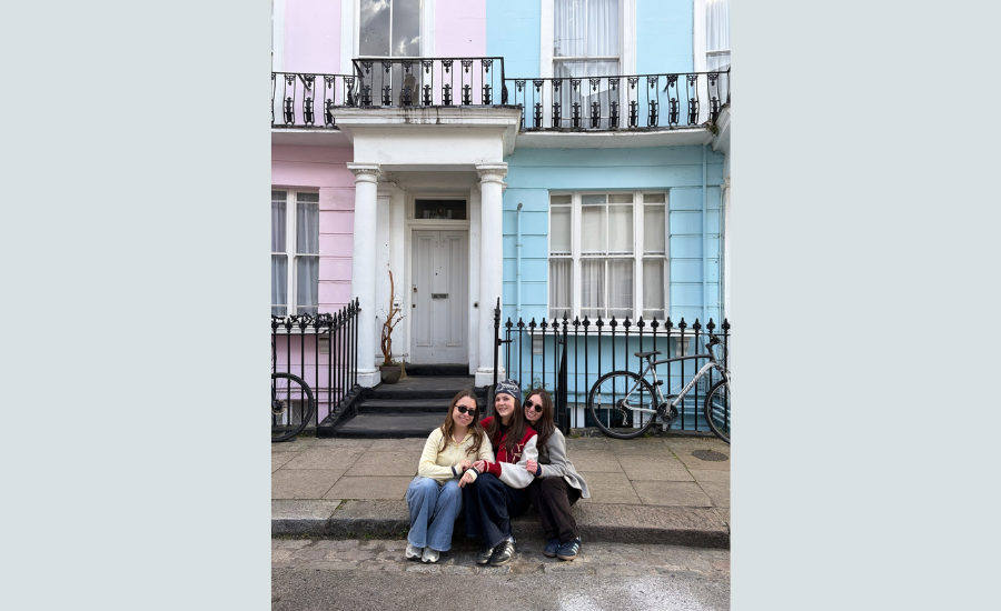 3 people in front of terraced house in London.