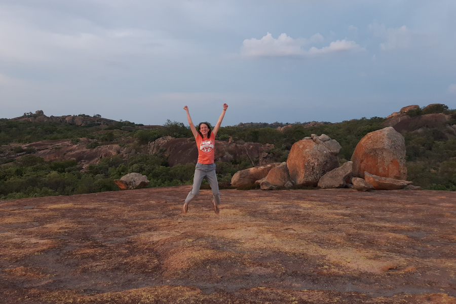 Vicky is jumping in the air forming a star shape in a national park