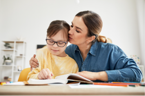 Child with Down’s Syndrome sitting with carer
