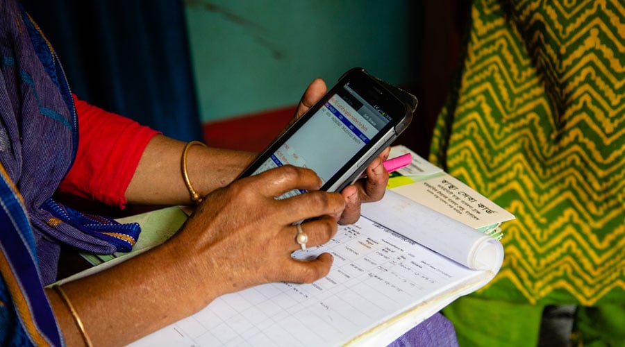 A community health worker collects demographic data using a tablet