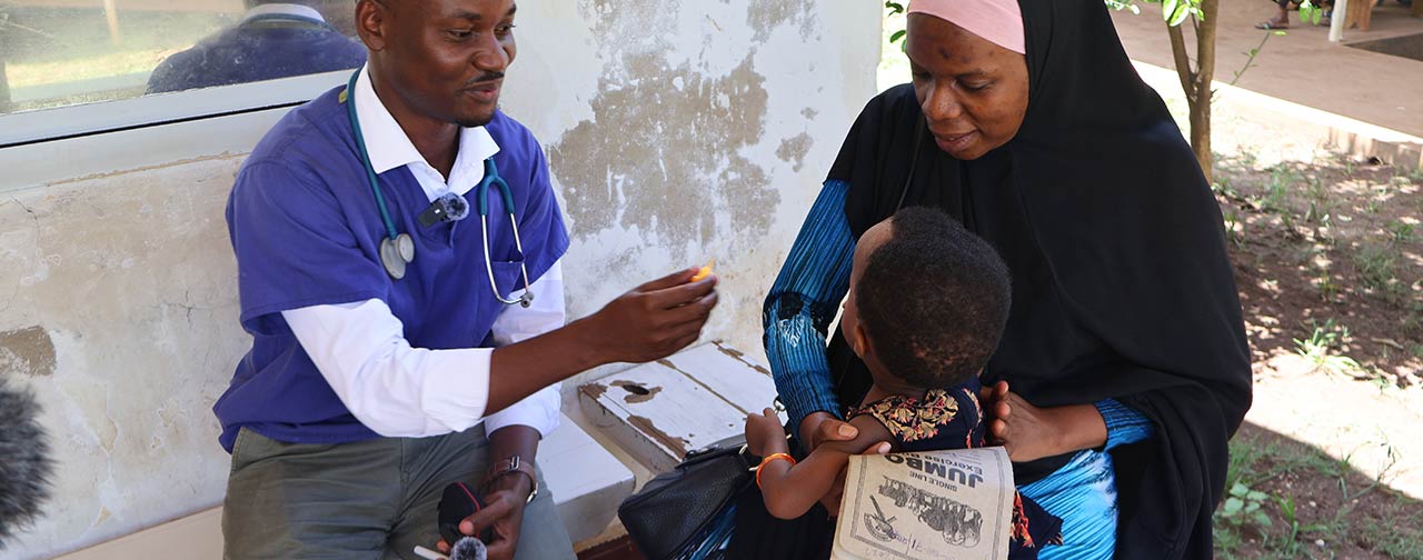 Healthcare worker administering eyedrops to baby