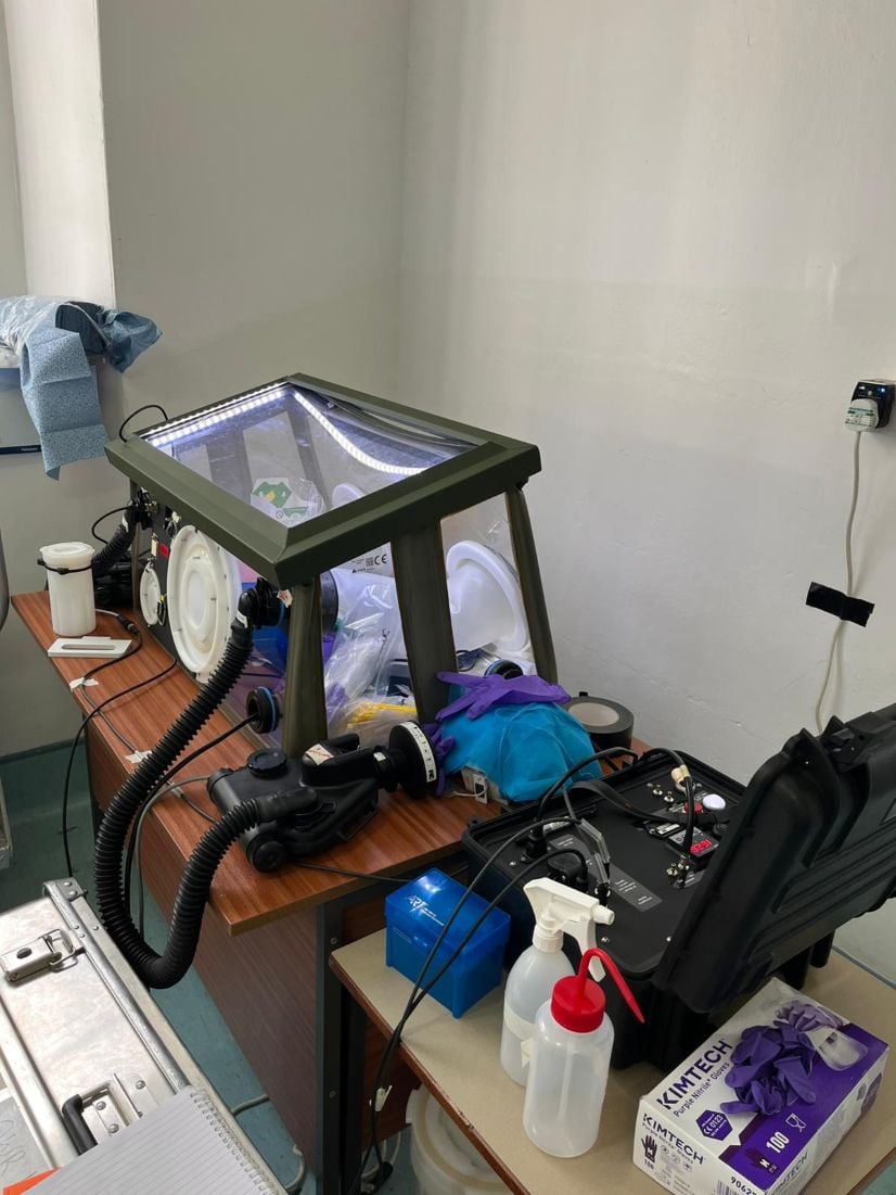 Rapid response mobile lab set up on desk in room including mobile pathogen isolation unit.