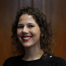 A woman with brown curly hair smiling