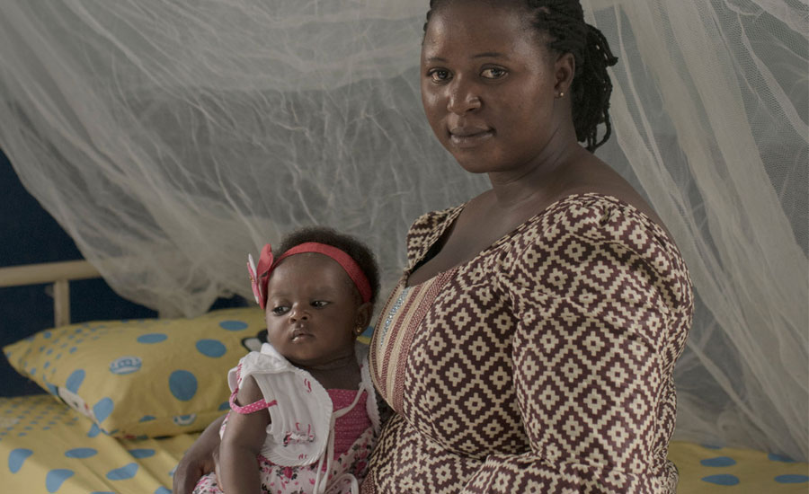Mother sitting on hospital bed, holding baby daughter in Plateau State, Nigeria