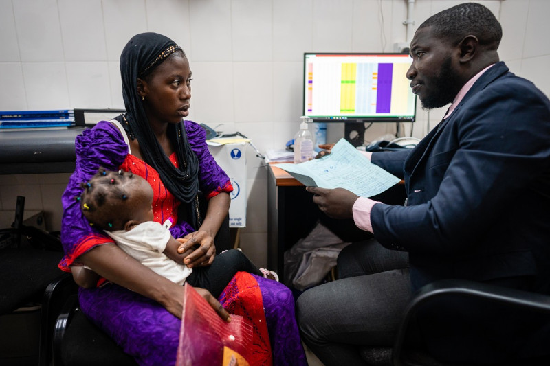 A mother holding her child meeting a clinician