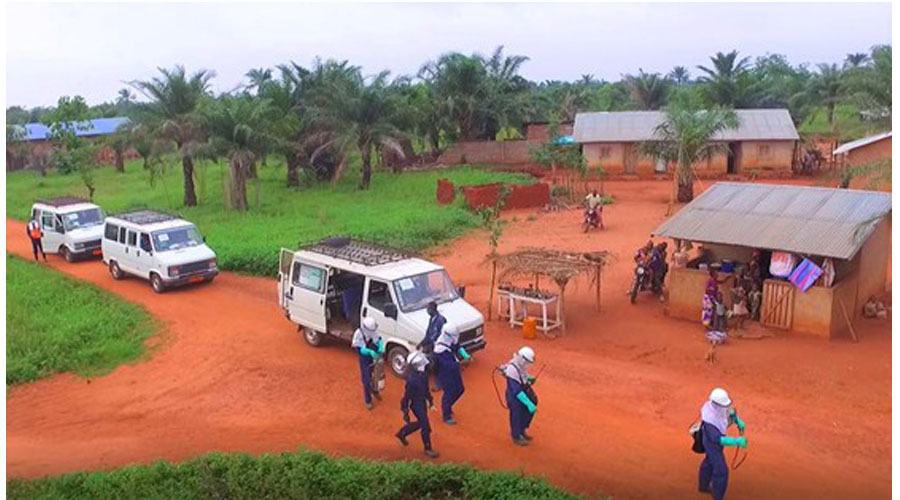 Spray team preparing to apply residual insecticide treatments to a households in a community trial. This work was part of a project evaluating new types of insecticide for improved control of malaria mosquitoes that developed resistance to existing insecticides.