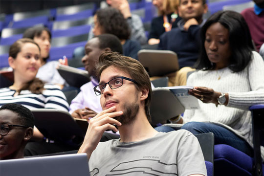 A group of students sitting in a lecture hall