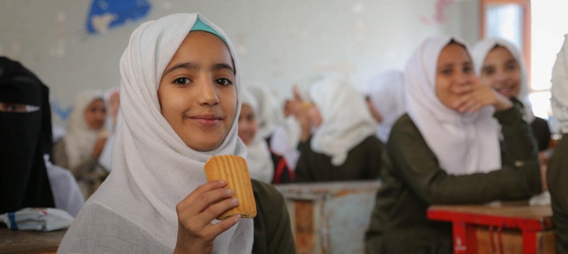 Girls at school in Palestine eat their biscuit snack