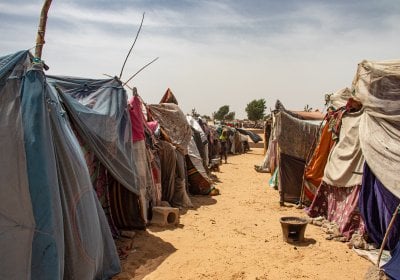 Two rows of make-shift tents on a desert floor