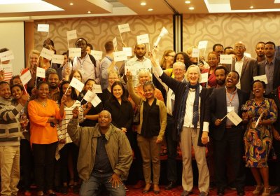 Group of LSHTM alumni in Ethiopia, holding LSHTM flags