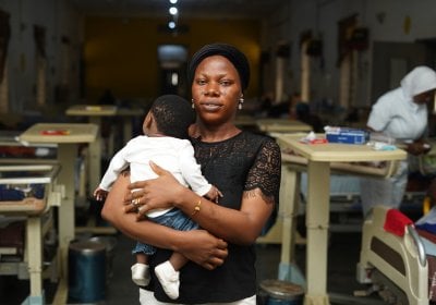 Woman holding a baby in a school setting