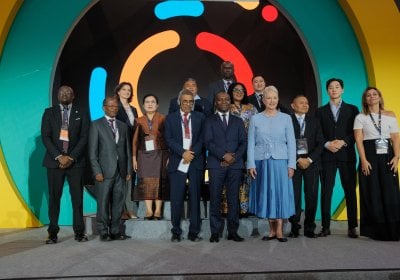 Group of men and women in suits on a stage in front of an SMC logo