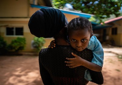 A woman carrying a child on her soulder