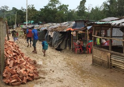 people walking in mud in rohingya camp