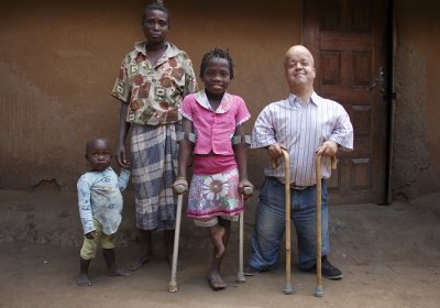 Caption: Prof Tom Shakespeare with Marta (10), a disabled girl who had been out of school in Buzi, Mozambique. Credit: Carlos Litulo