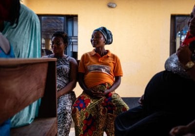 Pregnant women chat on benches while they wait to be seen by the nurse at the local Kuchigoro Primary Health Centre, Abuja.