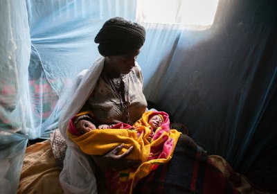 Newborn twins and their mother under a bednet in Ethiopia - Credit Paolo Patruno