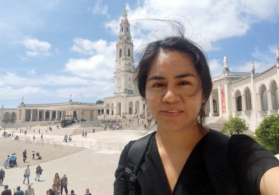 image of a woman standing in front of a building and plaza on a sunny day