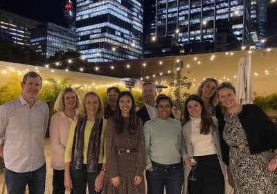 Group of alumni standing together at night time