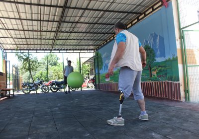Two people with amputated legs kicking a ball