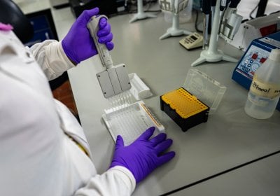 A technician runs tests in the laboratory, Fajara MRC Unit The Gambia at LSHTM.