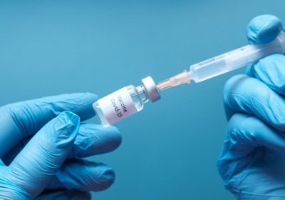 COVID-19 vaccine is drawn from a vial by syringe